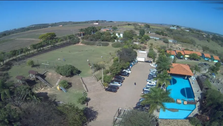 Vista aérea: campo, piscina e área de lazer